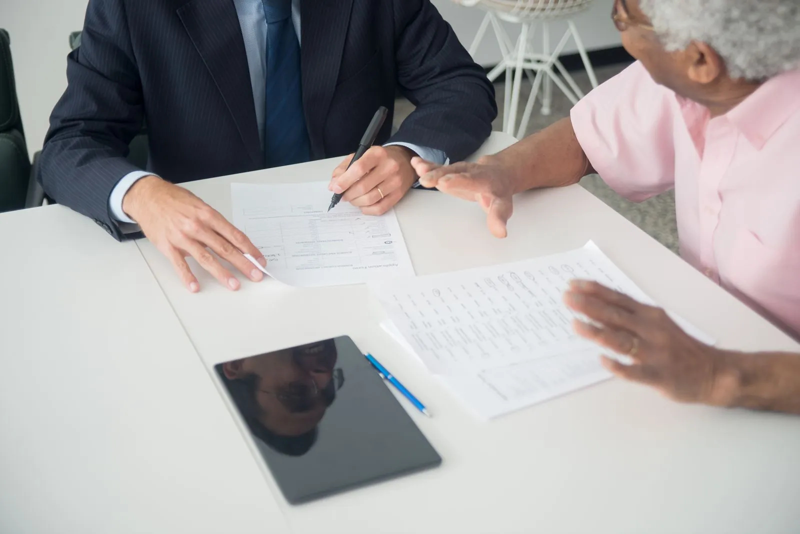 Senior client reviewing documents with an advisor at a table