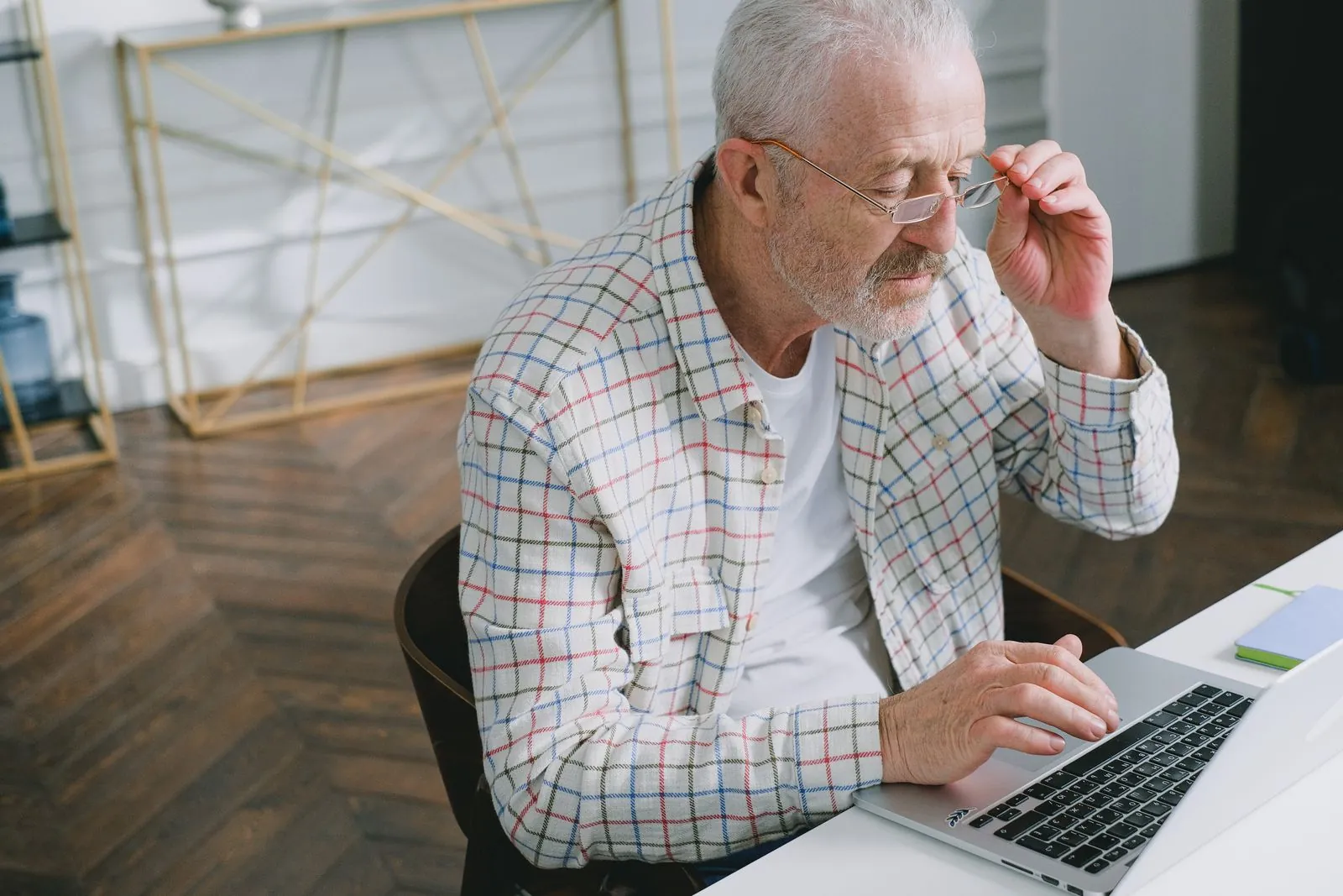 Older executive in glasses working on a laptop