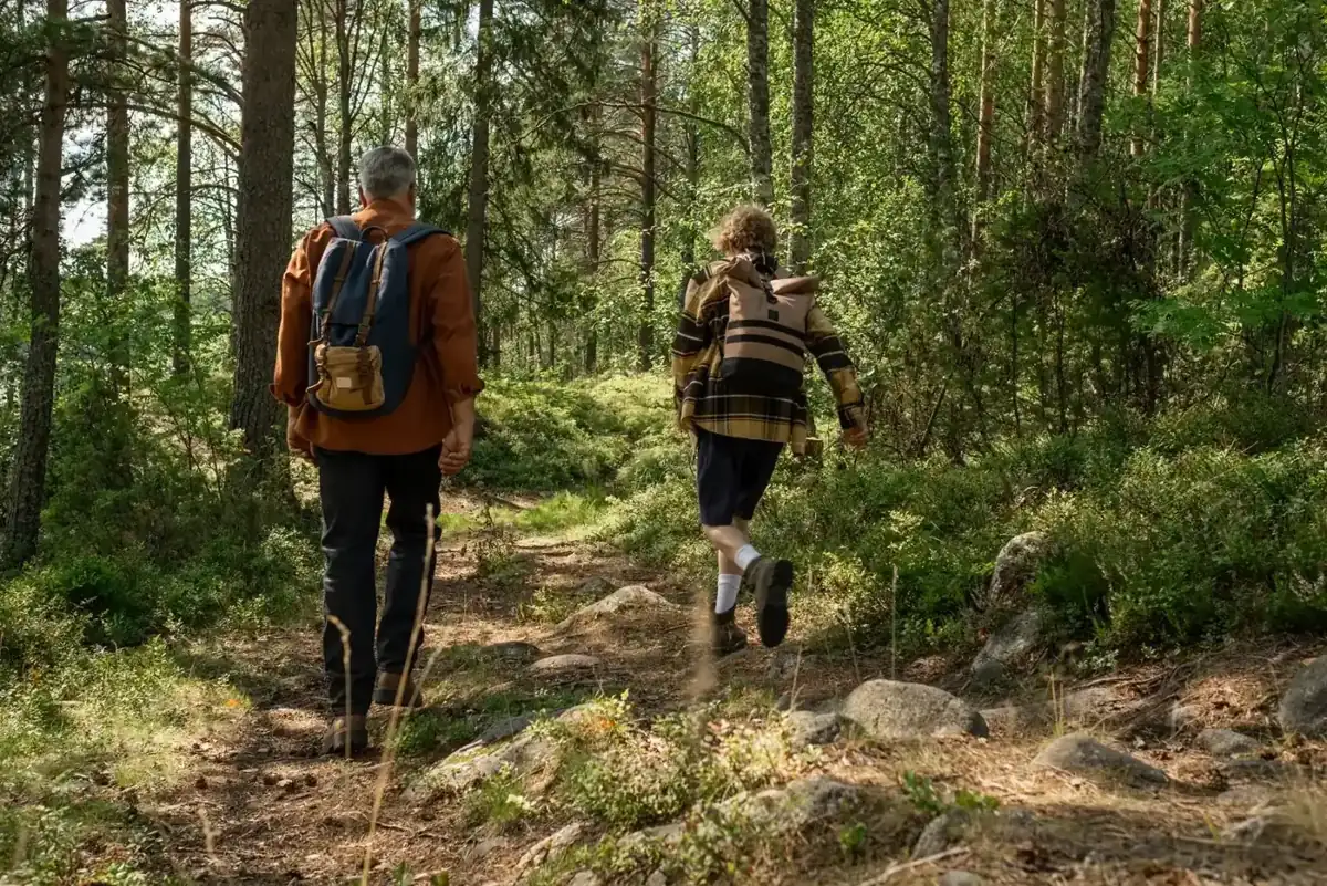 Grandfather and grandson hiking through a forest