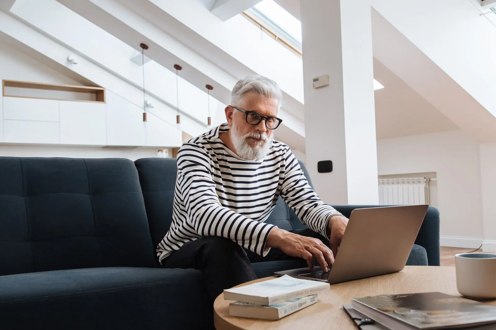 Senior executive working on a laptop in a modern living room