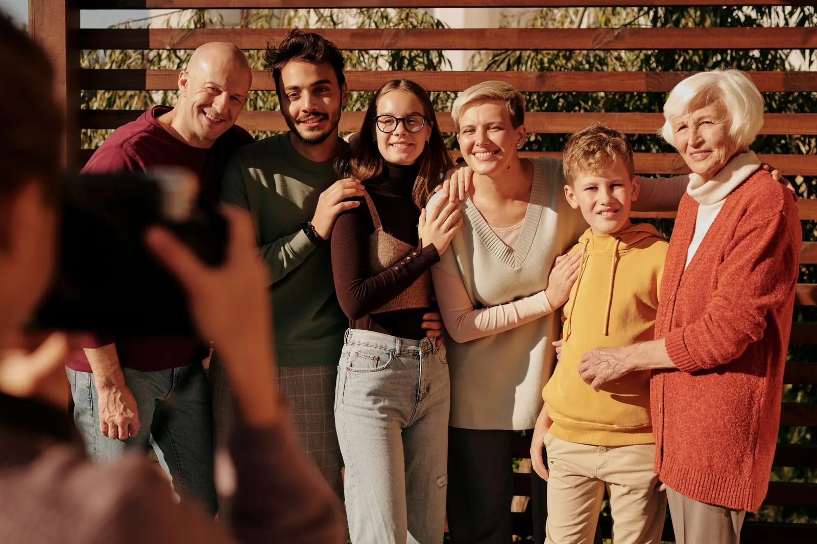 Three generations of a family smiling together outdoors